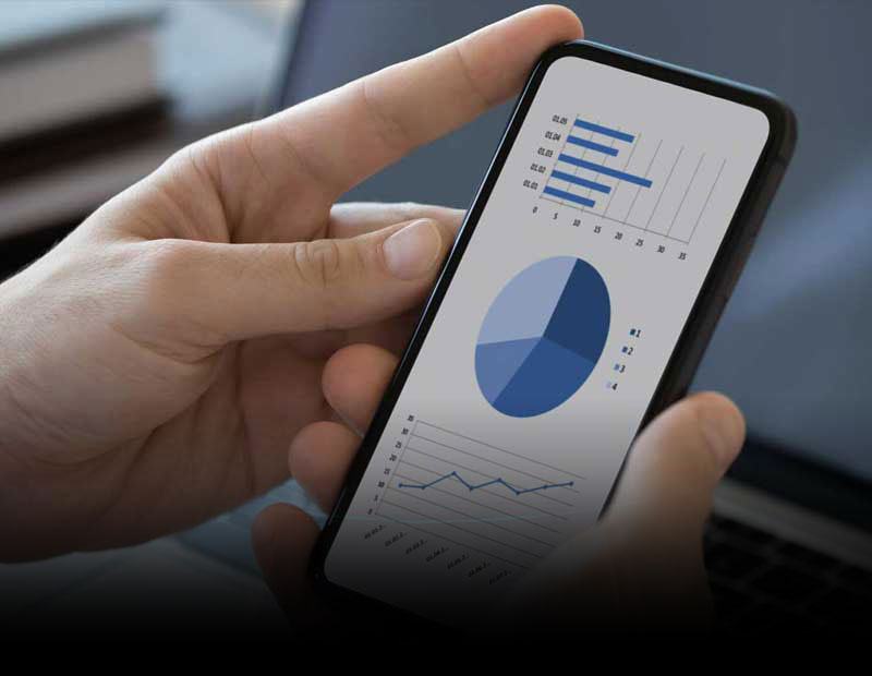 A person’s hands holding a mobile phone displaying financial data.