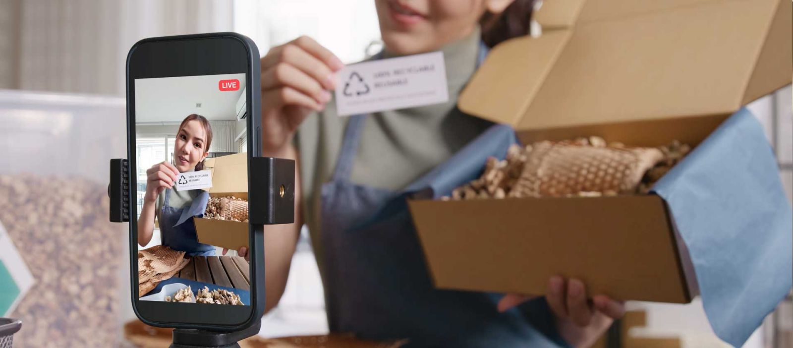 A female influencer is showcasing a product while streaming her presentation live on a mobile phone.